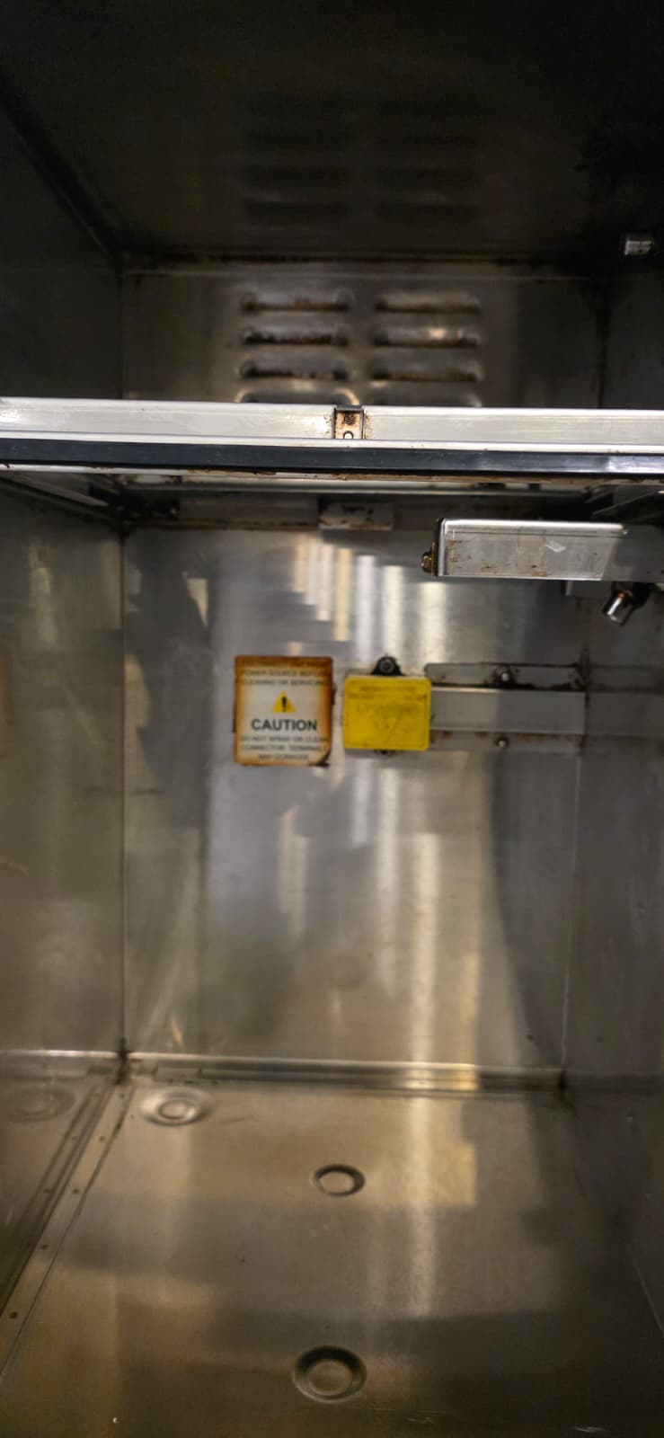 Close-up of the Perfect Fry interior rear panel and base after deep cleaning, with caution labels and upper vented panel visible.